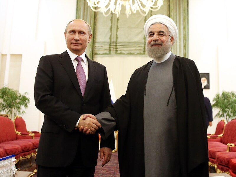 Russisch president Vladimir Poetin schudt Iraans president Hassan Rouhani de hand tijdens een top van gasexporterende landen in november vorig jaar.