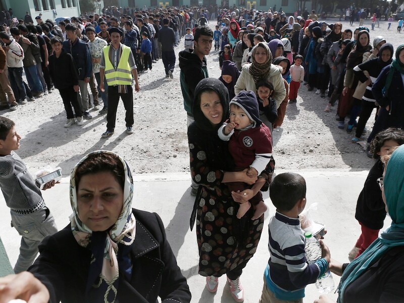 Migranten staan in de rij voor de voedselbedeling in een transitkamp in Schisto, een voorstad van Athene.
