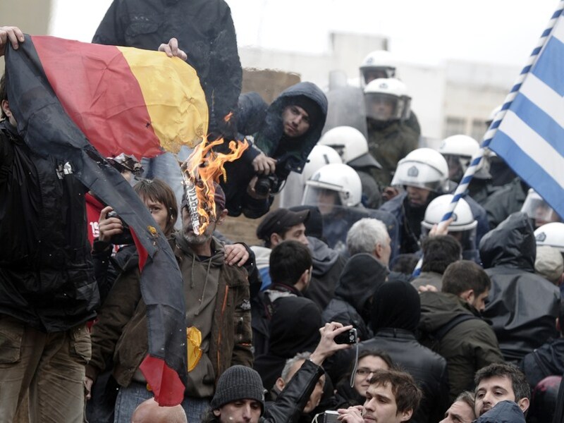 Griekse betogers steken een Duitse vlag in brand.