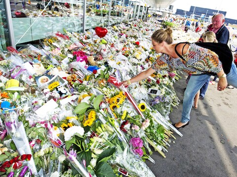 Een vrouw legt op Schiphol bloemen neer ter nagedachtenis van de slachtoffers van de neergehaalde MH17.