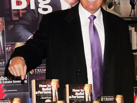 Donald Trump te midden van enkele van zijn cursusboeken.