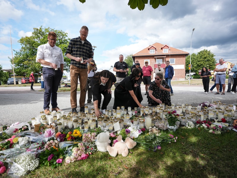 Beeld van 22 augustus. Mensen leggen bloemen en kaarsen neer voor de school in Fagersta, Zweden, een dag na de schokkende zwaardaanval.