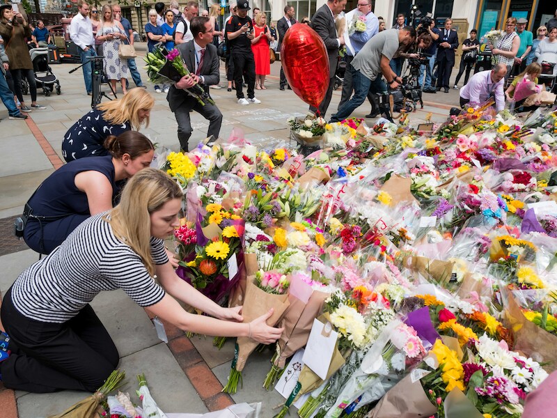 Vier dagen na de vreselijke aanslag zwelt het bloementapijt alleen maar aan. Mensen uit Manchester en daarbuiten komen steun betuigen.