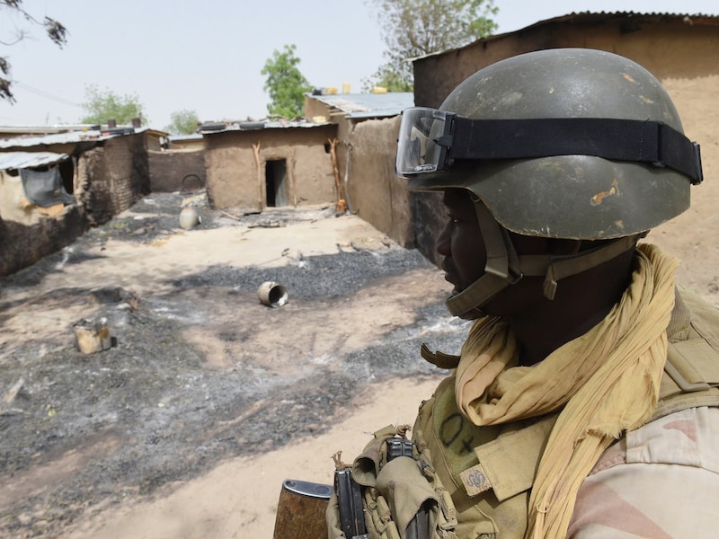 Een soldaat van het Nigeriaanse leger bij een uitgebrand huis na een overwinning op Boko Haram in het noordoosten van het land.