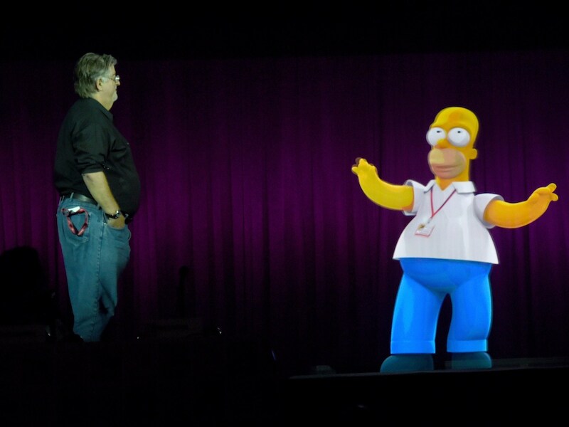 Matt Groening bewondert een hologram van Homer Simpson.