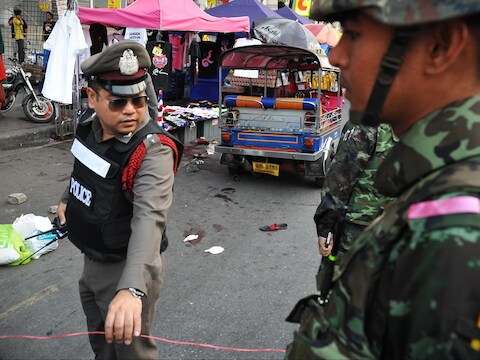 Politie en militairen zondag bij de plek in Bangkok waar een granaat twee mensen doodde.