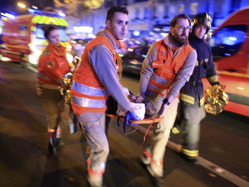 Een gewonde vrouw wordt uit de Bataclan gehaald op de avond van de aanslagen.