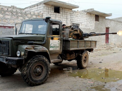 Een lid van rebellengroep Ahrar al-Sham bedient een machinegeweer in Aleppo.