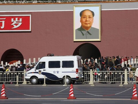 Een politiewagen bij de Poort van de Hemelse Vrede, waar ook het portret van Mao hangt. Maandag is hier een jeep op het publiek ingereden. Vermoedelijk was het een aanslag.