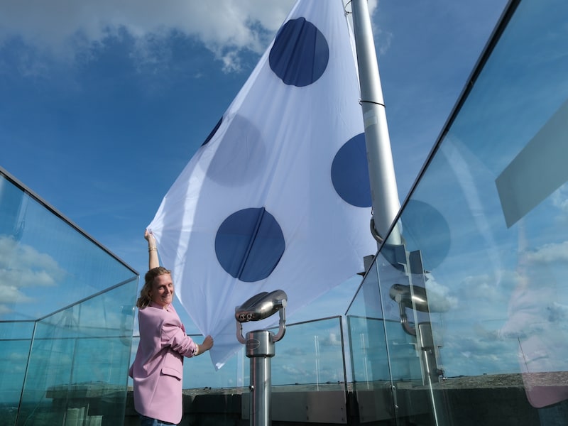 Schepen De Graef aan de STIP IT-vlag die boven de Sint-Romboutstoren wappert.