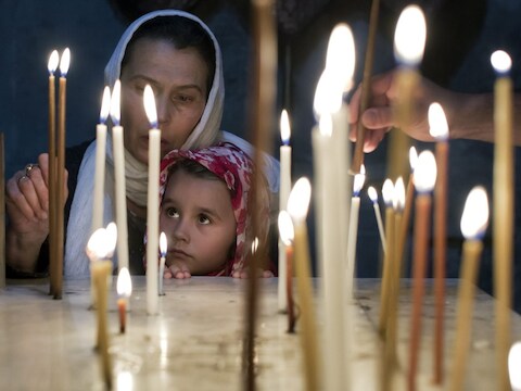 Orthodoxe gelovigen steken kaarsen aan in een kerk in Jeruzalem.