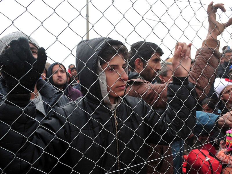 Vluchtelingen staan aan de grens bij Idomeni.