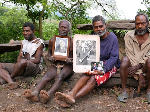 Chief Jack Malia (tweede van rechts) van de Imanourane Tribe houdt foto's van de Britse prins vast.
