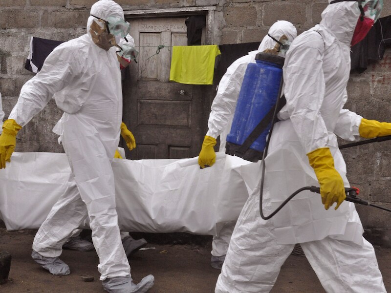 Gezondheidswerkers dragen het lichaam van een vrouw die aan ebola overleed weg in de Liberiaanse hoofdstad Monrovia.
