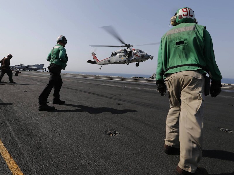 Een Amerikaanse gevechtshelikopter keert terug naar het vliegdekschip USS George H.W. Bush na een missie in Irak.