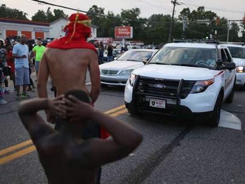 Demonstranten staan voor politieauto's in Ferguson