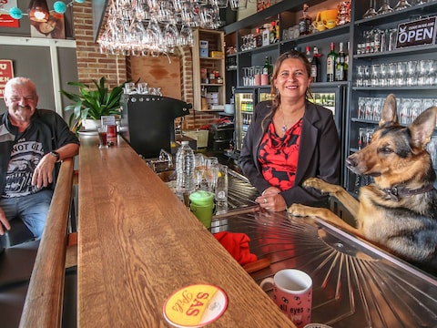 Cindy Trioen, haar Duitse herder Sunny en klant Rudi Derycke in café De Zon in Dranouter. 