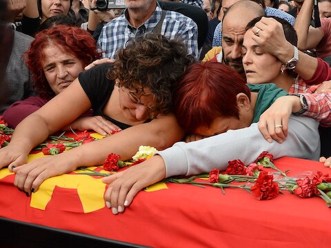 Familieleden van een van de slachtoffers rouwen bij zijn kust tijdens een begrafenisceremonie gisteren in Ankara. Duizenden demonstranten gaven de regering van president Erdogan de schuld van de bomaanslagen.