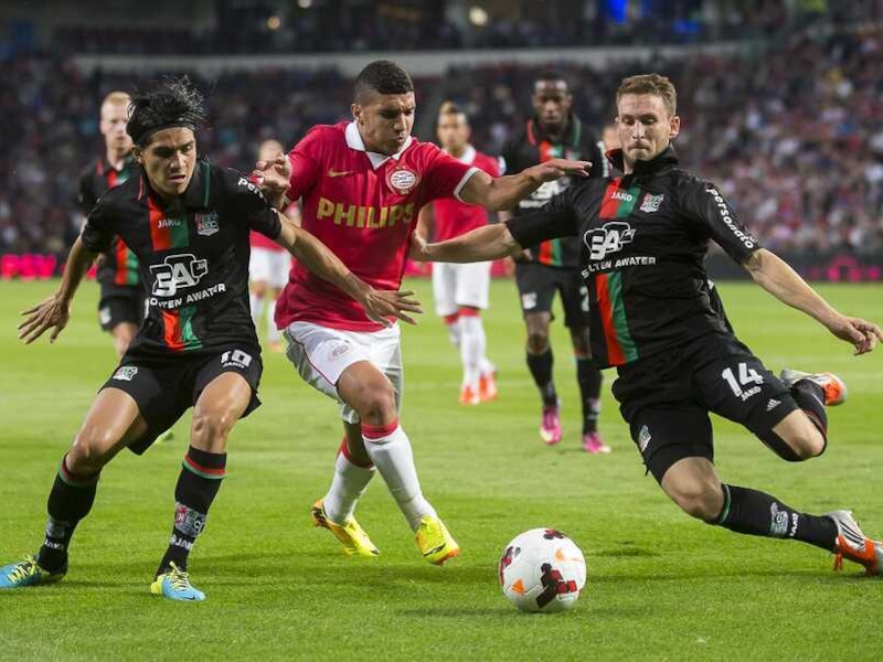 Zakaria Bakkali (midden) van PSV slalomt tussen Kevin Conboy (rechts) en Navarone Foor van NEC door.