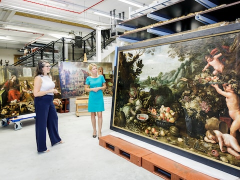 Lianne Kamminga, directeur van Museum Hof van Busleyden, en schepen Greet Geypen bewonderen in Depot Rato de drie schilderijen die werden gerestaureerd voor de expo Bourgondisch tafelen.