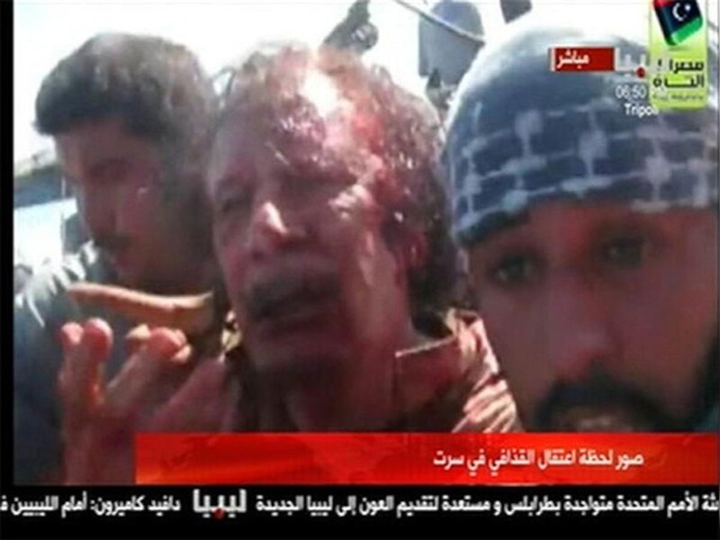 Versuft en gewond, maar duidelijk nog in leven. De laatste momenten van Kadhafi.