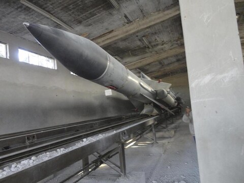 Syrische rebellen fotograferen raketten die ze vinden in ingenomen legerbasissen van de regering.