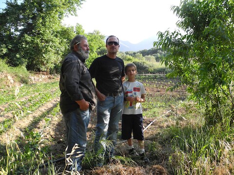 Stelios (71), zoon Nikos (45) en diens zoon Ilias (9) in hun pas aangelegde 'crisistuin'.