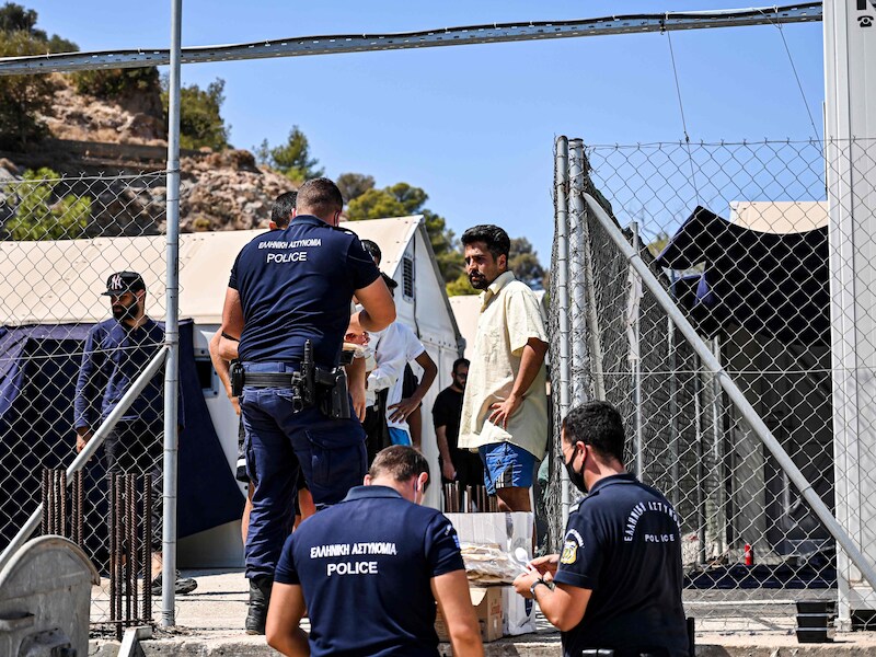 Archiefbeeld. De politie deelt voedsel uit onder recent aangekomen migranten op het Griekse eiland Samos. (07/09/21)