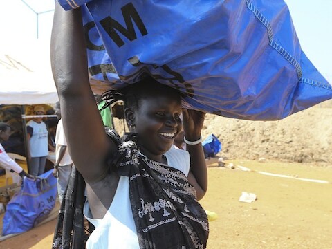 Een vrouw in Zuid-Soedan draagt een overlevingspakket van de WFP.
