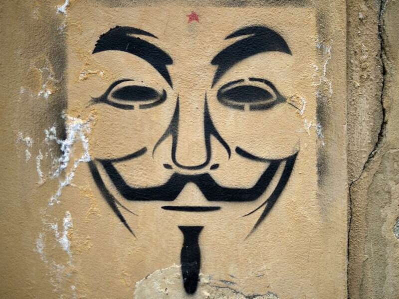 Het gezicht van Guy Fawkes, het symbool van Anonymous, op een muur.