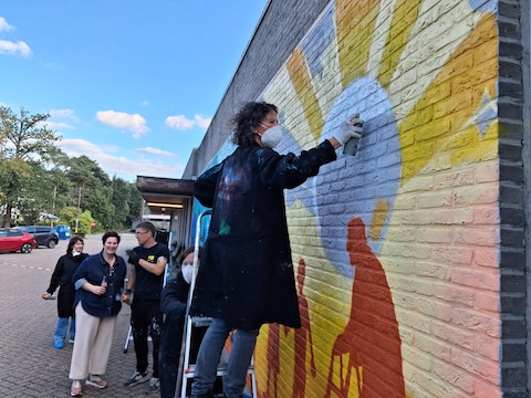 Enkele CM-vrijwilligers en graffiti-artiest Rick Molyneux brachten een muurschildering aan op een gebouw van zorgverblijf Hooidonk in Zandhoven.