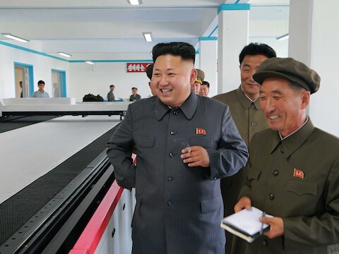 De Noord-Koreaanse leider Kim Jong-il krijgt een rondleiding in een fabriek.