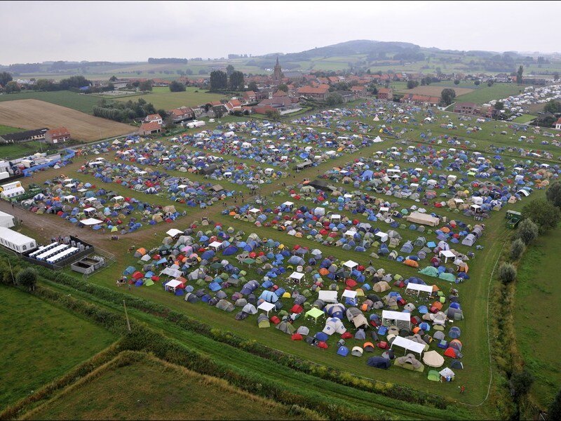 De campingweide van het festival en bovenaan in beeld de kerk van Dranouter, waar het Rode Kruis toegang tot heeft.
