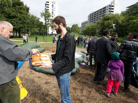 Een vrijwilliger deelt broodjes uit in het Brusselse Maximiliaanpark.