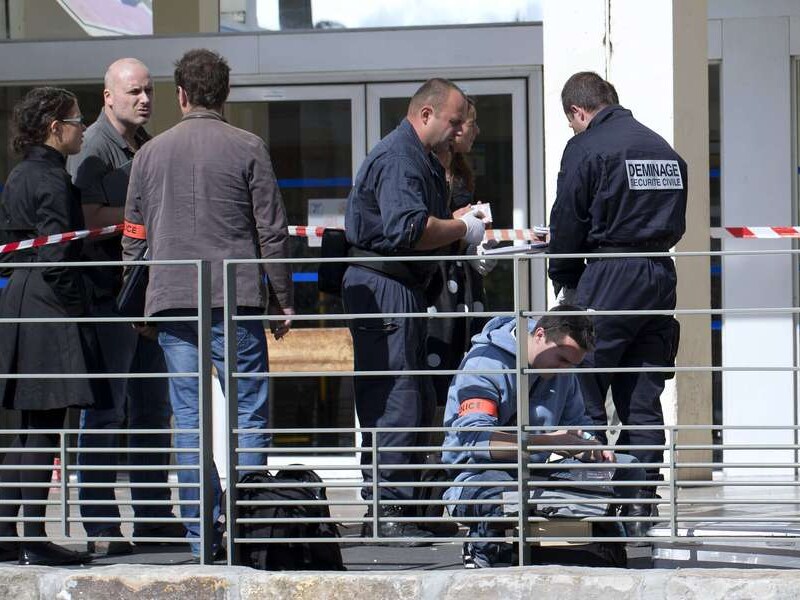Politieagenten onderzoeken de plaats van de bomaanslag.