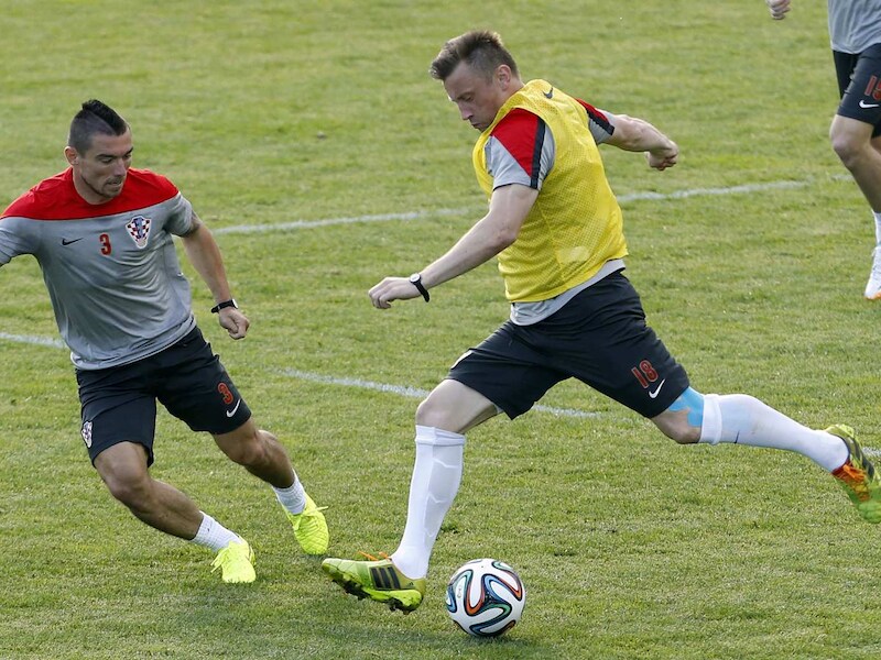 Pranjic (L) probeert hier een schot van Olic af te blokken.