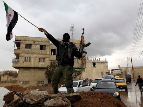Een aanhanger van het Syrische verzet tegen het regime van Bashir al-Assad zwaait met een rebellenvlag in Damascus.