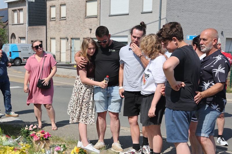 Bjorn (midden), de vriend van begeleidster Anke en familieleden aan de plaats waar bloemen gelegd worden in nagedachtenis van de slachtoffers.