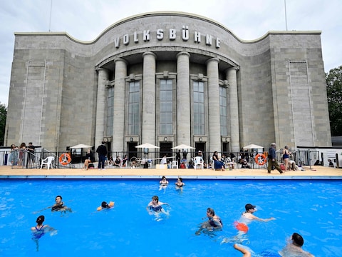 Bezoekers zwemmen in het tijdelijk zwembad dat is aangelegd voor het Volksbühne-theater aan het Rosa-Luxemburg-Platz in Berlijn.