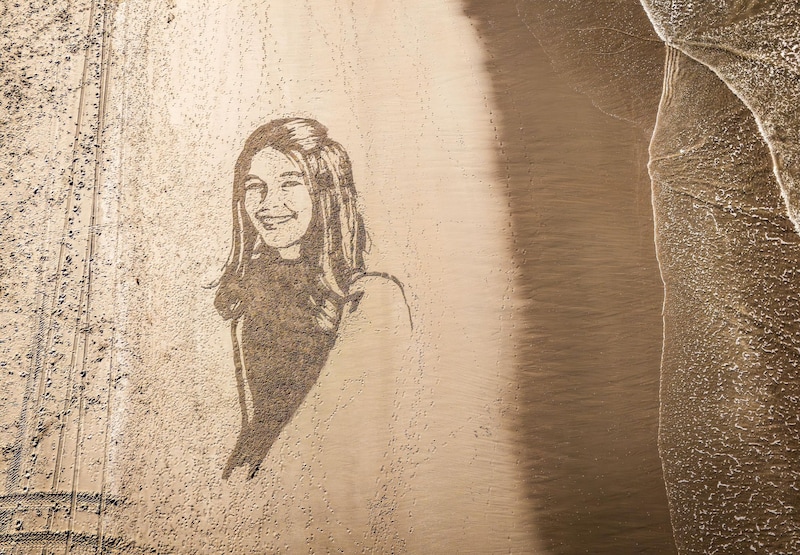 Een portret van Jade Kops in het zand. 