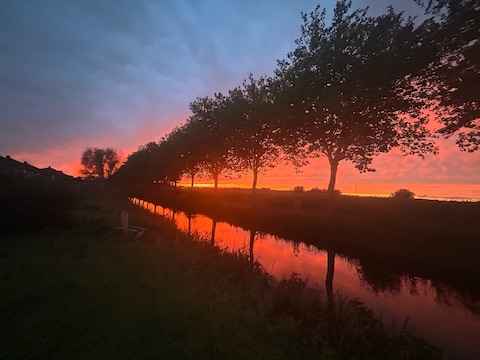 Hemel boven Kluizen kleurt felrood en oranje bij zonsondergang
