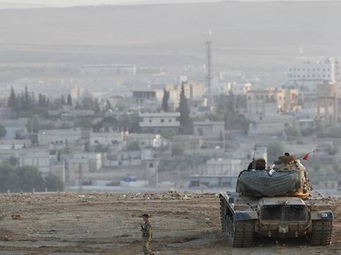 Turkse tanks houden de wacht bij de Turks-Syrische grens. In de verte ligt Kobane.