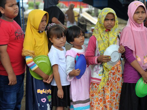 Kinderen staan in de rij voor een voedselbedeling in Pidie Jaya, in de provincie Atjeh.