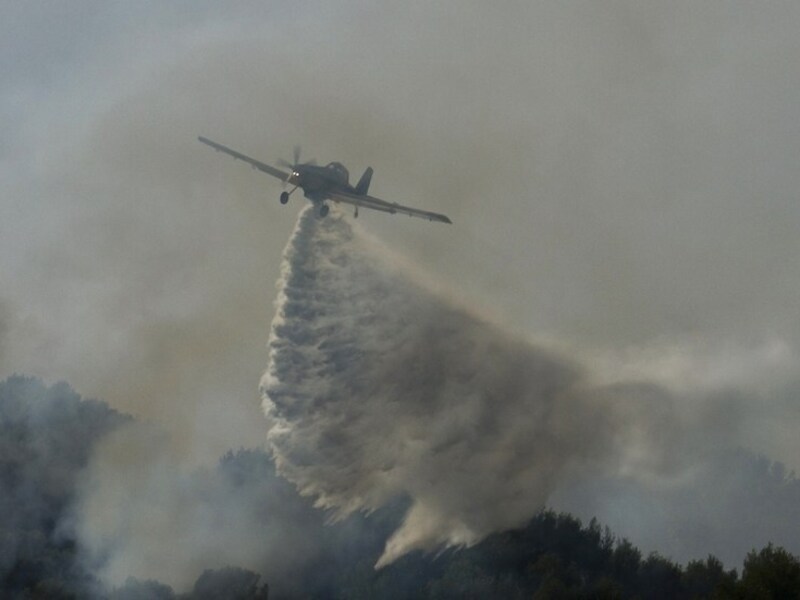 Een blusvliegtuig boven de brandende bossen van Mallorca.