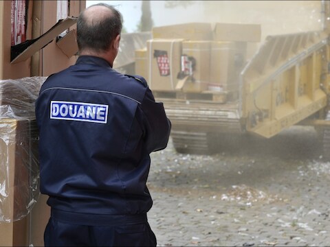 Een douanier kijkt toe op de vernietiging van 151 miljoen namaaksigaretten.