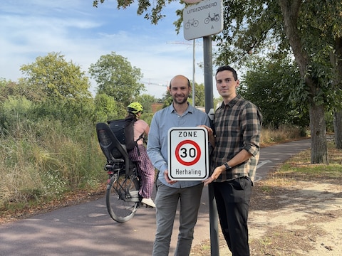 Mortsels burgemeester Michiel Hubeau (links) en mobiliteitsschepen Jitse Born tonen een bordje dat aangeeft dat je op de F1 maximum 30 kilometer per uur mag fietsen.