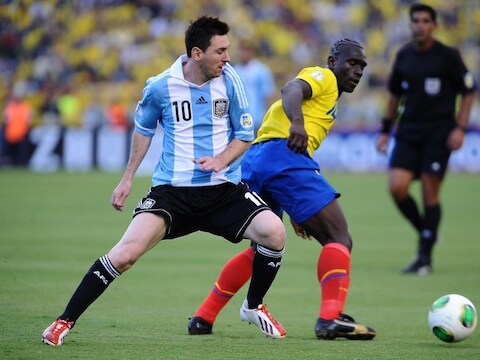 Lionel Messi (Argentinië) in duel met Segundo Castillo van Ecuador.