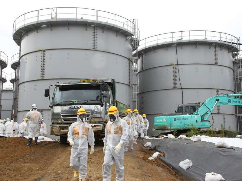 Inspecteurs en Tepco-medewerkers bij de opslagtanks van de centrale van Fukushima.