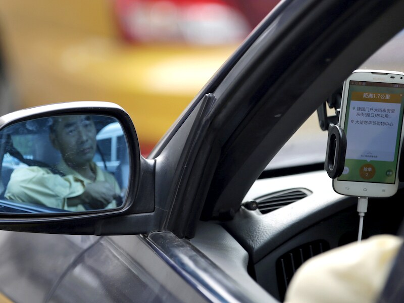 Een Chinese taxichauffeur gebruikt de Didi Chuxing-app.