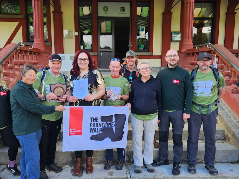 Deelnemers aan The Frontline Walk van het Army Benevolent Fund poseren samen met de geschonken objecten. Derde van links staat Iain Forbes, schenker van de voorwerpen; vierde van links staat Evy Van de Voorde, collectieverantwoordelijke van het Passchendaele Museum. 